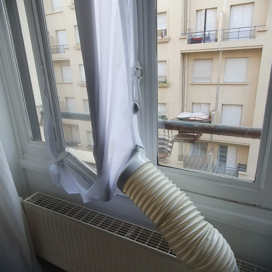 Tuyau d'évacuation d'un climatiseur mobile raccordé à la fenêtre avec kit de calfeutrage, installation à Lyon